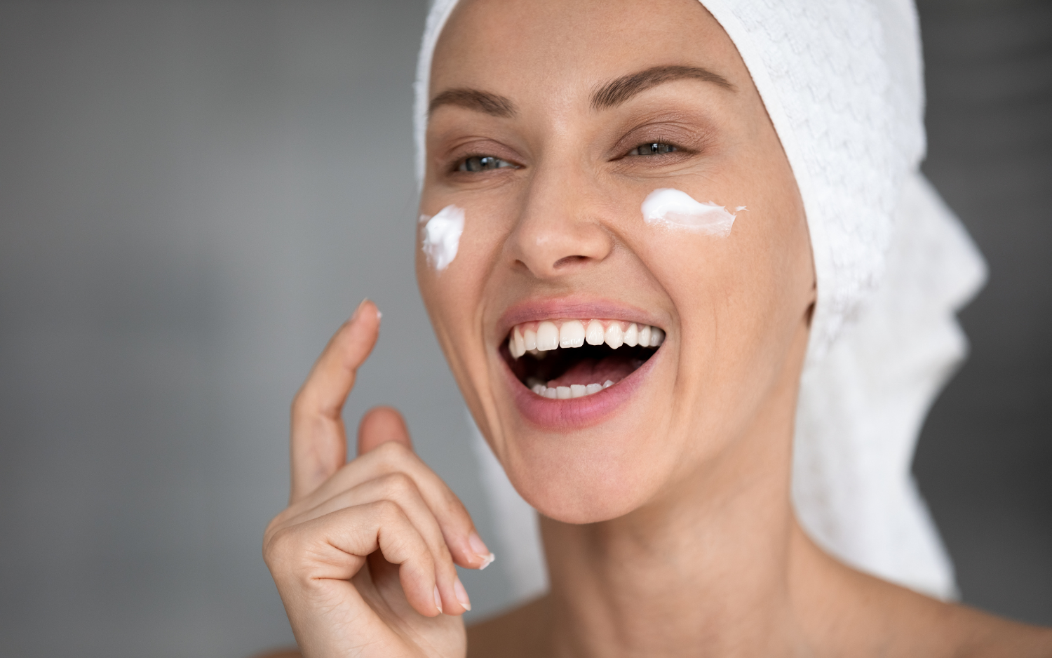 women laughing applying lotion to face 