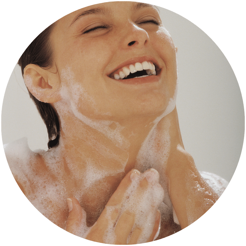 woman lathering her neck and body with Nefertem bar soaps