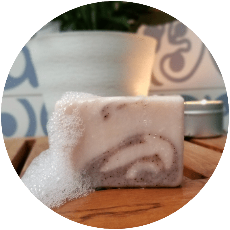 Nefertem bar soap with lather on wooden table