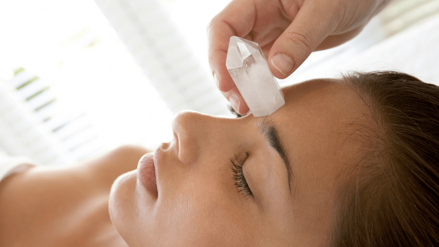 woman performing crystal therapy using clear quartz crystal
