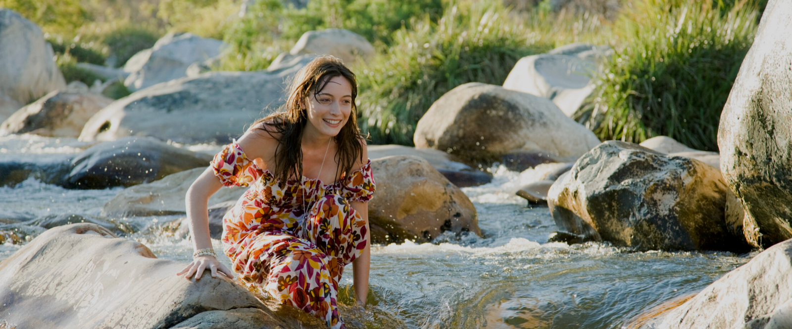 woman crouching in creek after using natural skin care