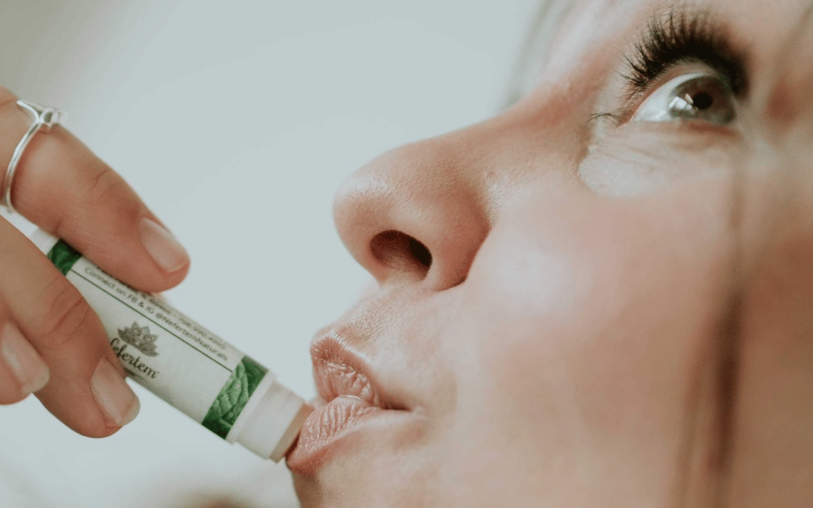 woman applying lip balms to lips