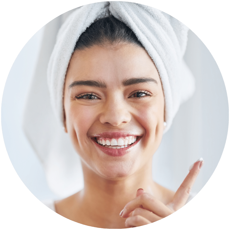 happy woman putting Nefertem moisturizer on her face