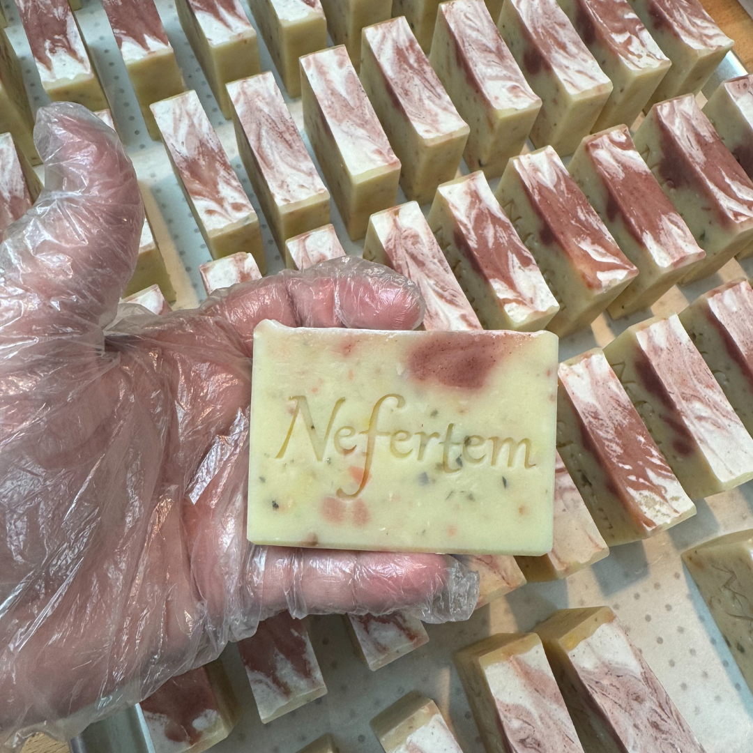 holding grace tallow soap with hand above other soaps
