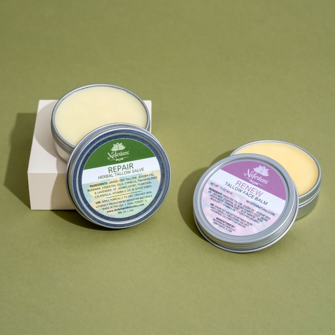 Two tins of Nefertem tallow salves on a green background