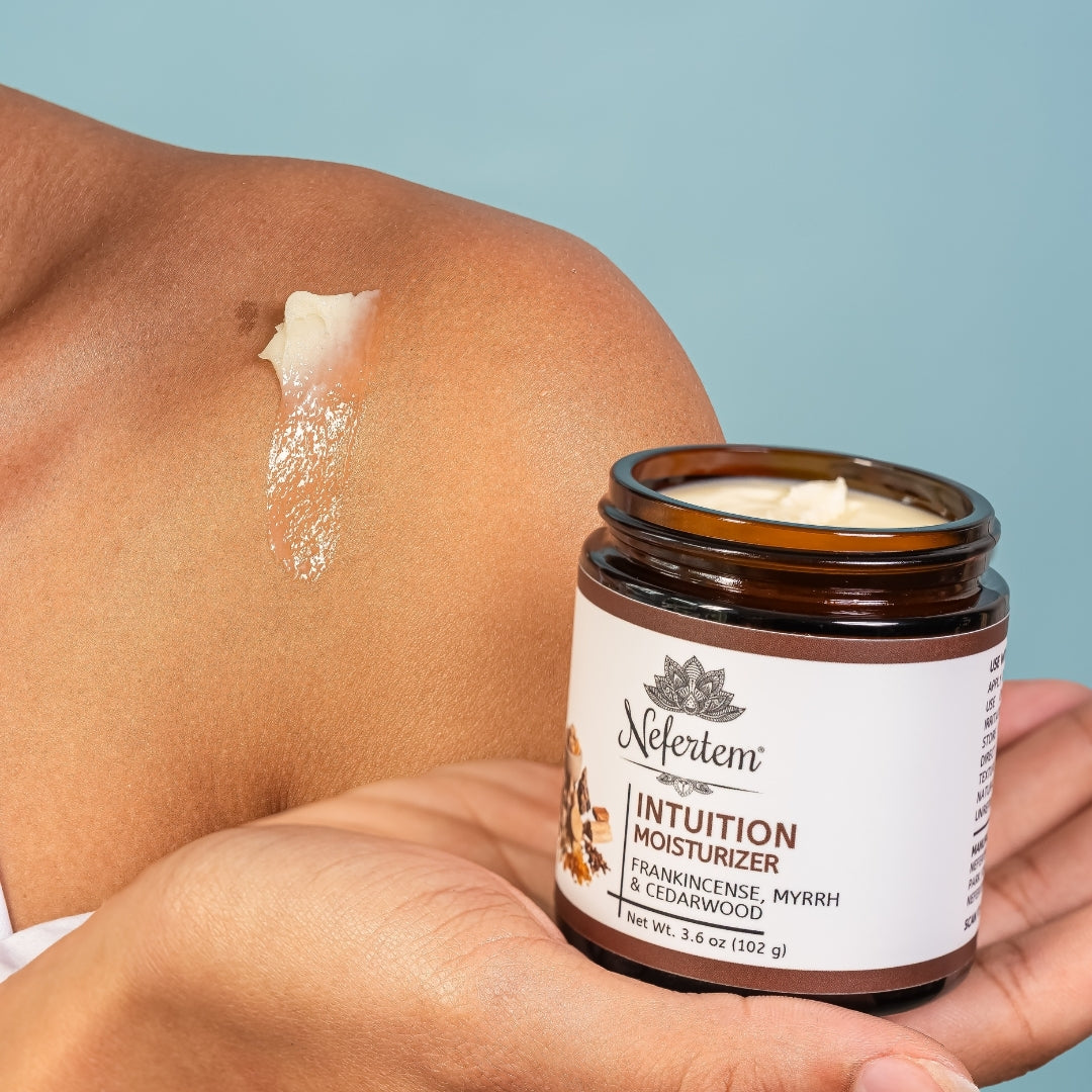 Jar of Nefertem Intuition Tallow Moisturizer with a hand applying cream to skin