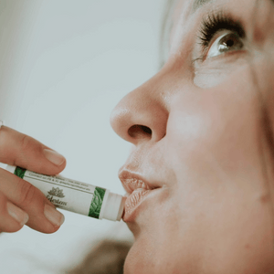 applying natural lip balm to lips