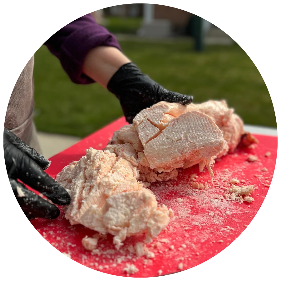 showing person cutting grass-fed beef suet outisde by hand